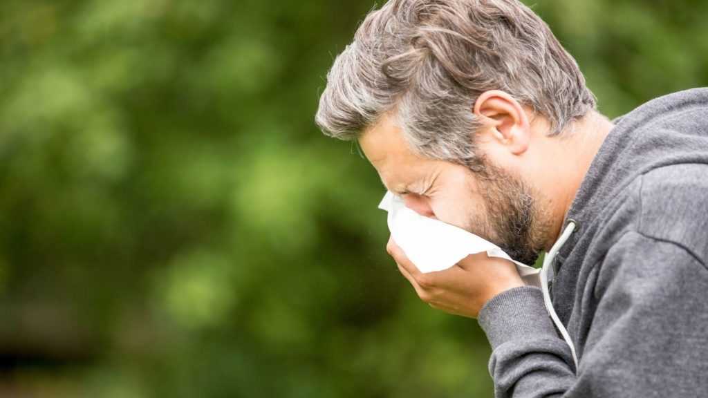 a man sneezing due to flu